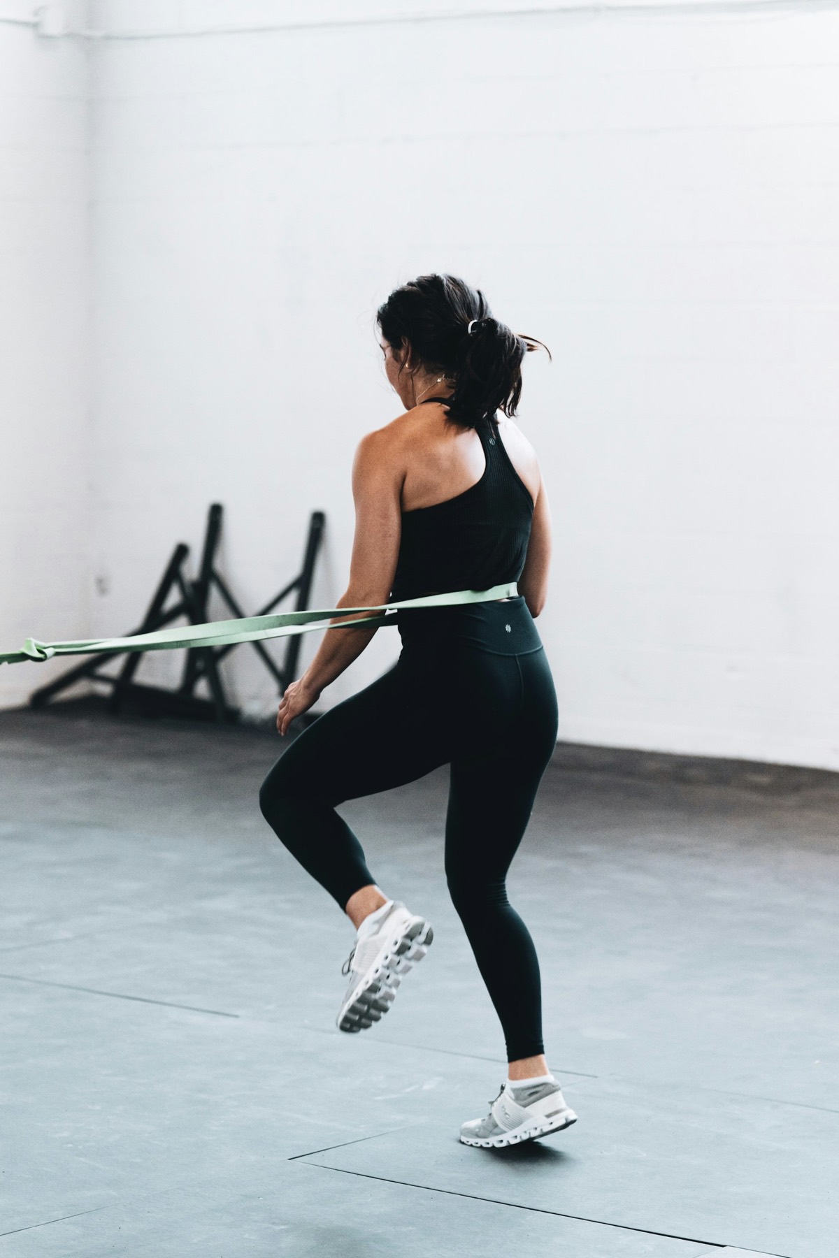 A woman steps sideways in a quarter squat with a resistance band around her legs